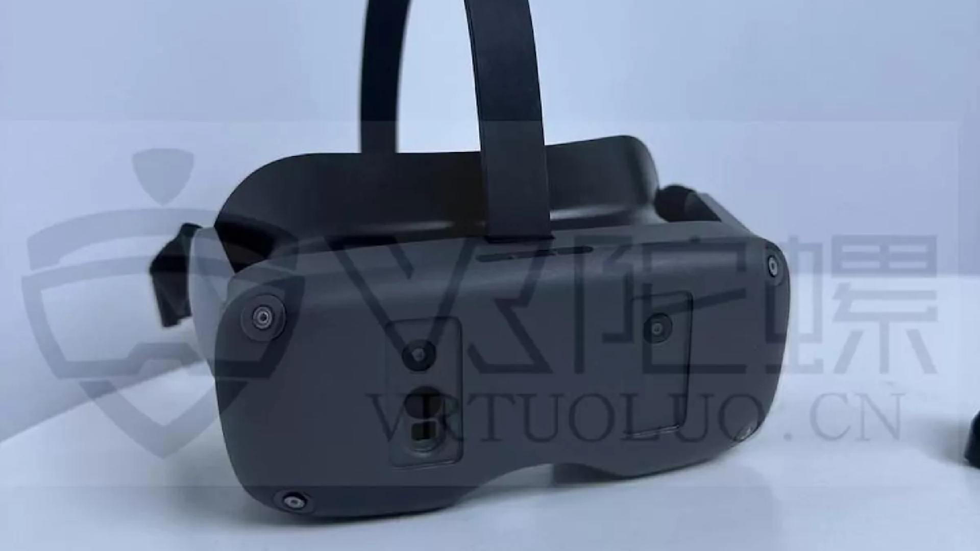 A VR headset cla in black plastic with a simple strap and six visible cameras on its faces