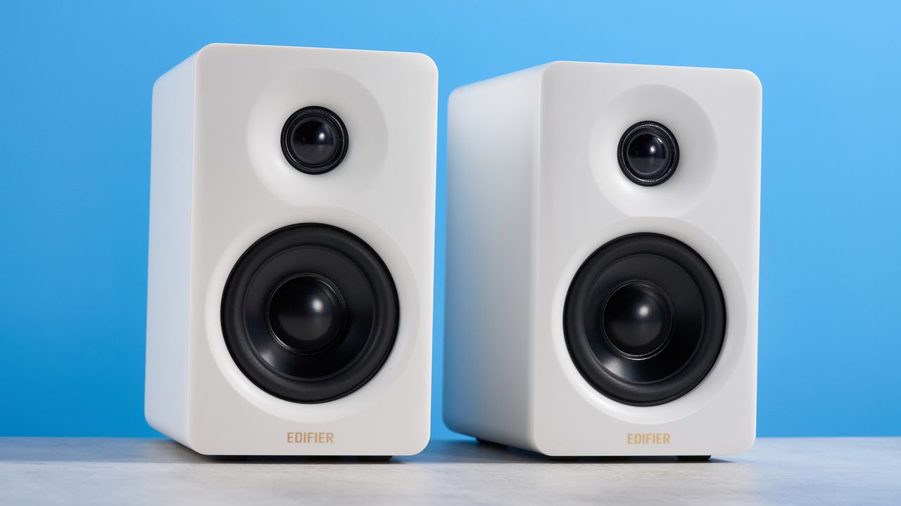 the edifier m60 bookshelf speakers in white photographed against the blue tom's guide background
