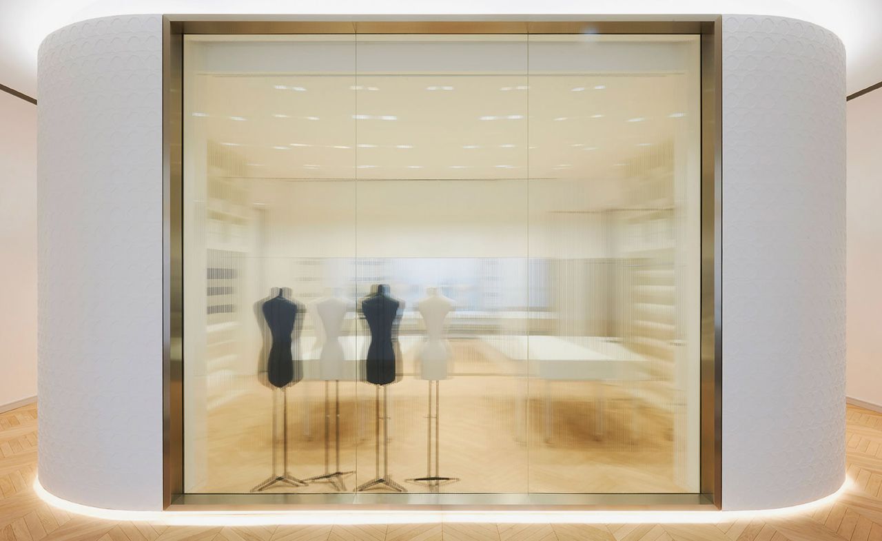 A view through incised glass to the space where garments are received after restoration or prepared for loans. The surrounding plaster wall is cast in Dior’s woven cane-inspired cannage pattern.