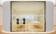 A view through incised glass to the space where garments are received after restoration or prepared for loans. The surrounding plaster wall is cast in Dior’s woven cane-inspired cannage pattern.