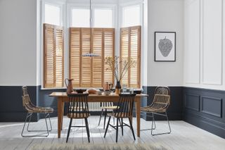wooden dining table, wooden shutters, rattan dining chairs, dark grey and white colour scheme