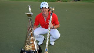 Rory McIlroy with the DP World Tour Championship trophy and the Race to Dubai trophy