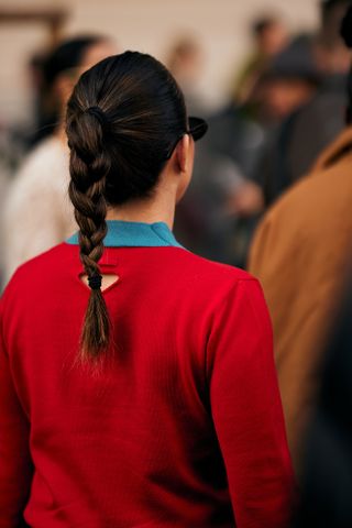 braided ponytail at milan fashion week woman in a red sweater