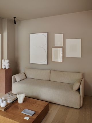 A taupe living room with walls and ceiling same color and a few frames