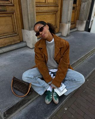 @amaka.hamelijnck wearing jeans, jumper and suede jacket