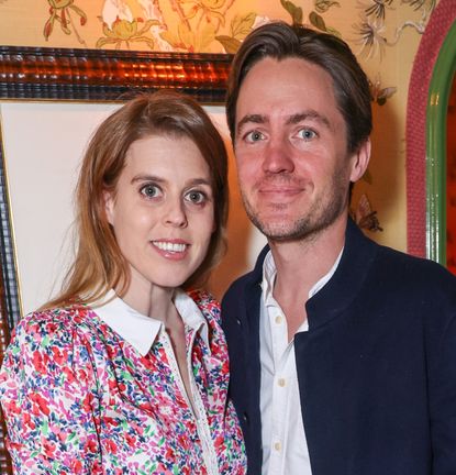 Princess Beatrice wearing a floral dress smiling and standing next to Edoardo Mapelli Mozzi 