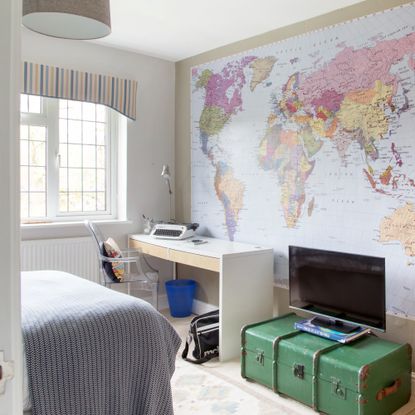 A teenager's bedroom with a large world map poster on the wall