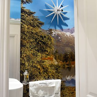 cloakroom with wall clock and white wall with wallpaper