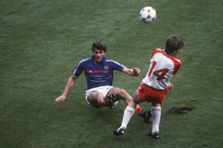 France defender Yvon Le Roux clears the ball under pressure from Denmark's Michael Laudrup at Euro 1984.