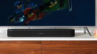 the Sonos Beam soundbar on a cabinet beneath a TV