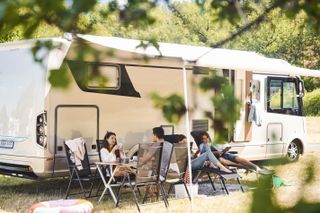 A family relaxing outside their camper van now that caravan parks are re-opening.
