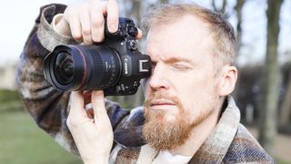 Canon RF 14mm F1.4L VCM lens in photographer Tim Coleman's hands, attached to an EOS R5 mark II
