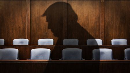 Silhouette of Donald Trump against a jury box