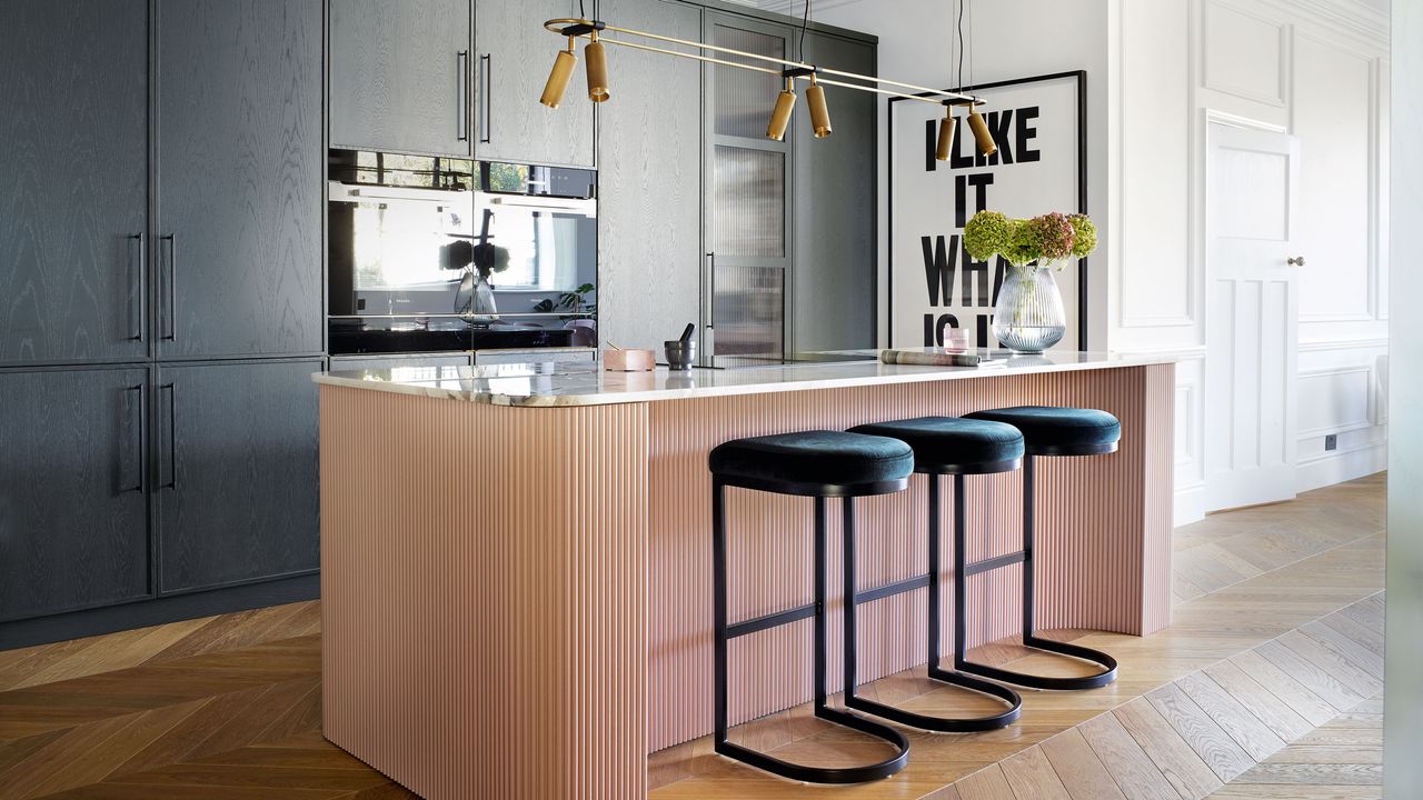 period and modern design black and pink kitchen with a pink breakfast bar and black bar stools