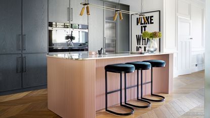 period and modern design pink and black kitchen with black bar stools and a pink breakfast bar