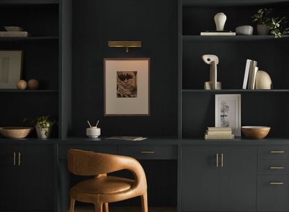 A home study with built-in wall shelving painted dark grey 