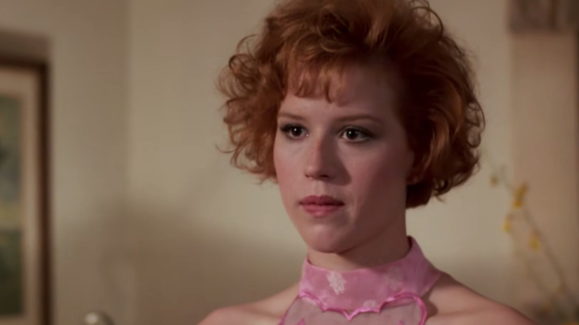 A close up of Molly Ringwald with a pink choker on in Pretty in Pink