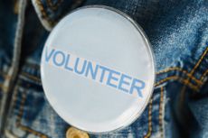 Volunteer pin on a jean jacket for AmeriCorps tax story