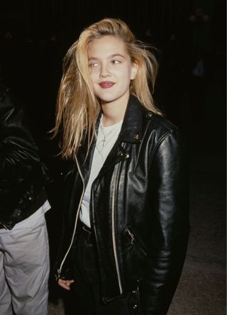 American actress Drew Barrymore, wearing a white t-shirt beneath a black leather jacket, attends the Century City premiere of 'Longtime Companion', held at Cineplex Odeon Century Plaza Theatres in Century City, California, 14th May 1990. (Photo by Vinnie Zuffante/Getty Images)