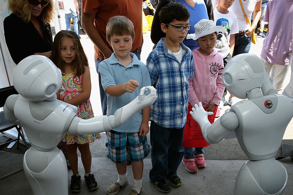Children interact with Aldebaran's Pepper robot during the Defense Advanced Research Projects Agency (DARPA) Robotics Challenge Expo at the Fairplex June 6, 2015 in Pomona, California.