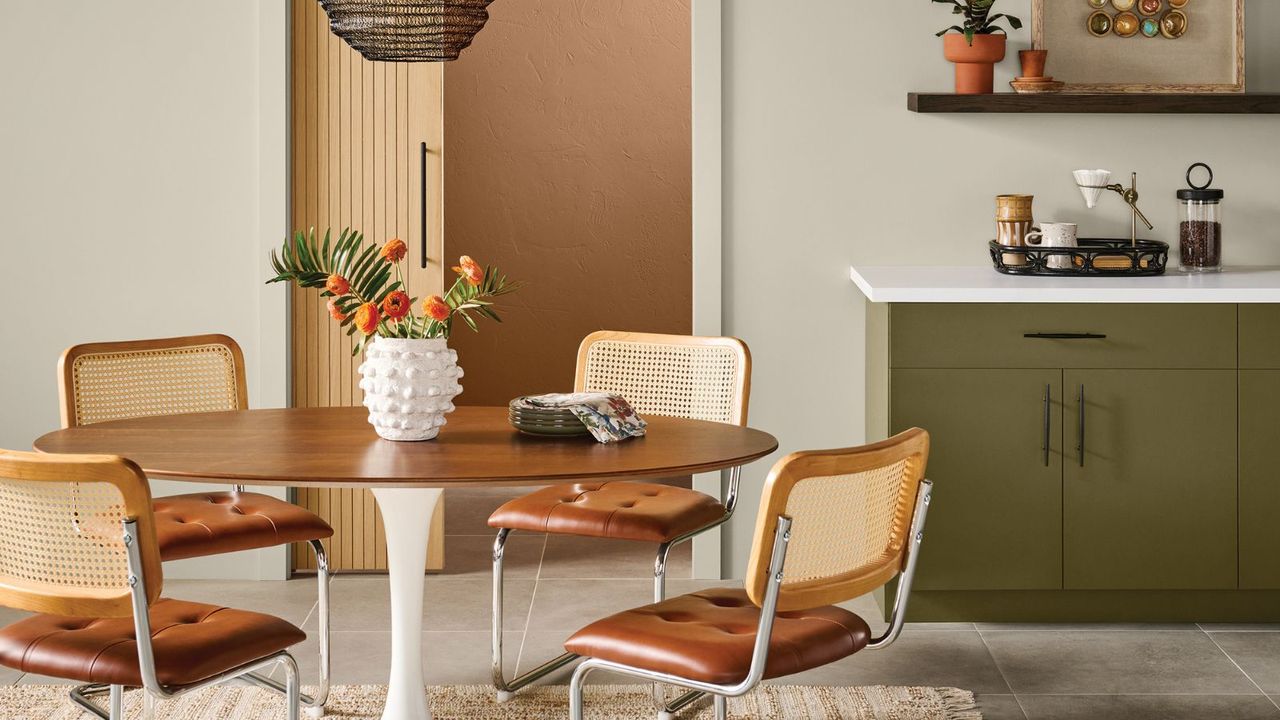 modern kitchen with neutral walls, olive green cabinets, round wood dining table with rattan dining chairs