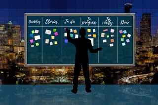Person in front of a Kanban board with sticky notes in different columns