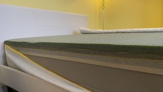 Image shows the cover unzipped on the Eve Premium Hybrid mattress during the review process to show the multiple layers of premium foam