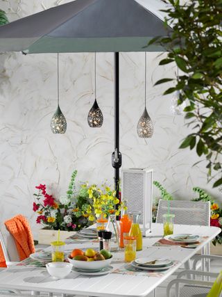Solar pendant lights hanging over garden table and chairs