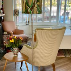 Corner of room with two armchairs, table lamp and side table with vase of flowers
