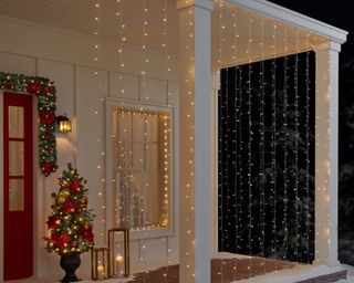 Christmas porch with string light curtain lanterns candles and Christmas tree