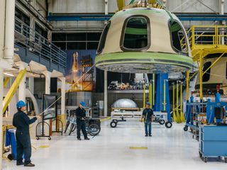 Blue Origin workers move a spacecraft component at the company’s Kent, Washington, factory.