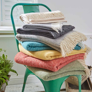 colourful blankets stack on green chair