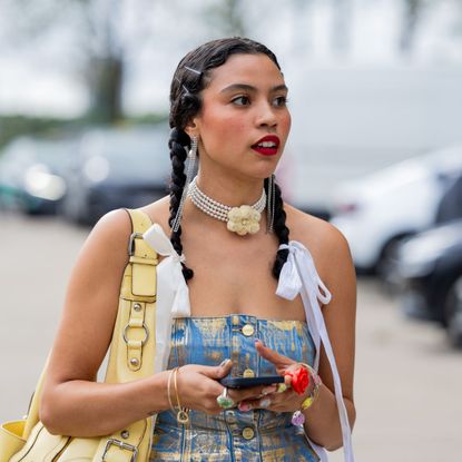 street style shot of woman with two plaits and red lipstick