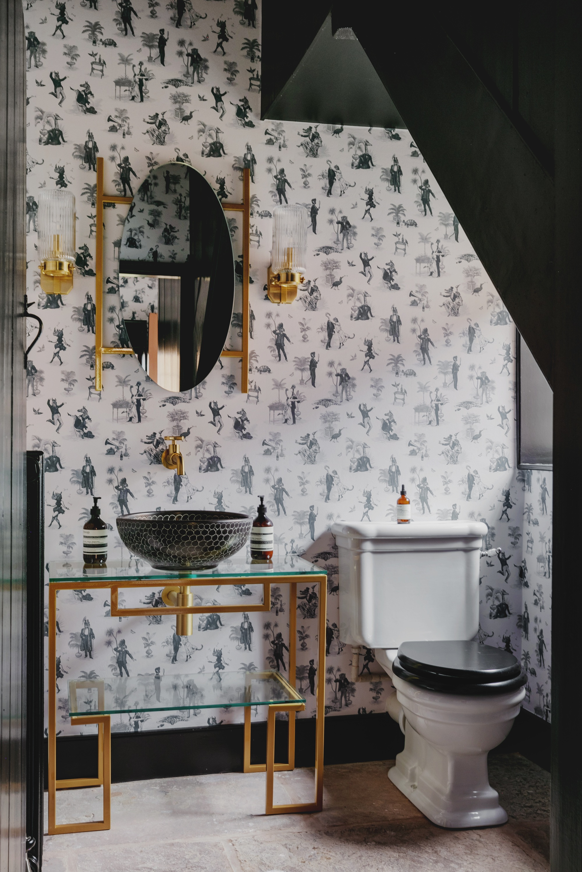 an art deco bathroom with a brass vanity and mirror