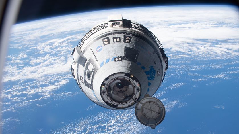 A white and blue Boeing Starliner capsule floats above a blue Earth with the black of space in the background.