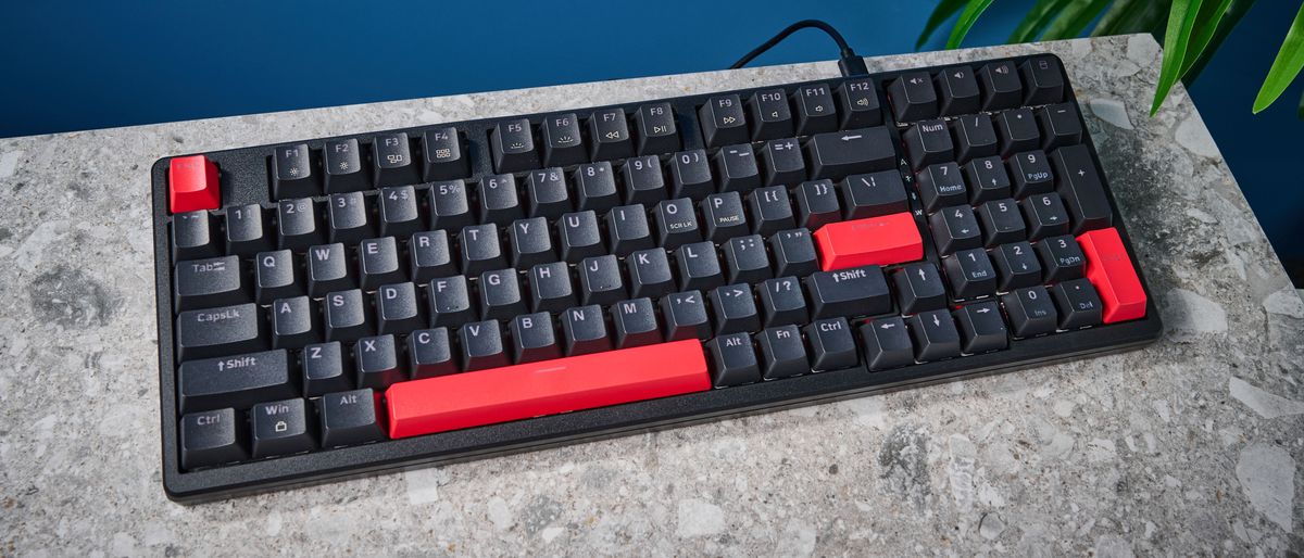 A black Lemokey X5 wired mechanical keyboard with red and black keycaps