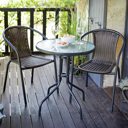 Argos Home 2 Seater Rattan Effect Garden Bistro Set in brown on a wooden veranda.