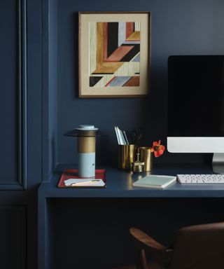 blue rechargeable light on desk in room with navy blue walls