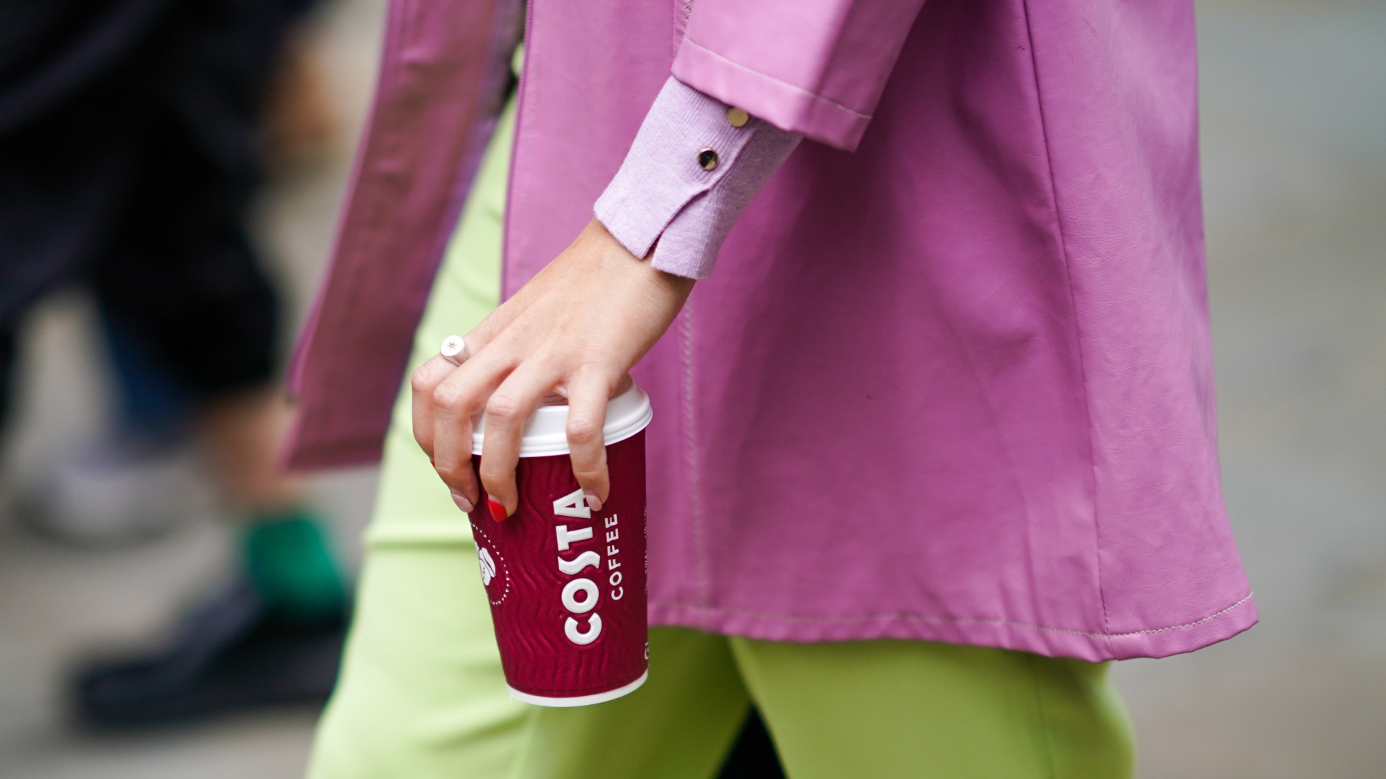 Woman holds Costa Coffee cup