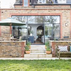 red brick wall house with bifold door and plants pot