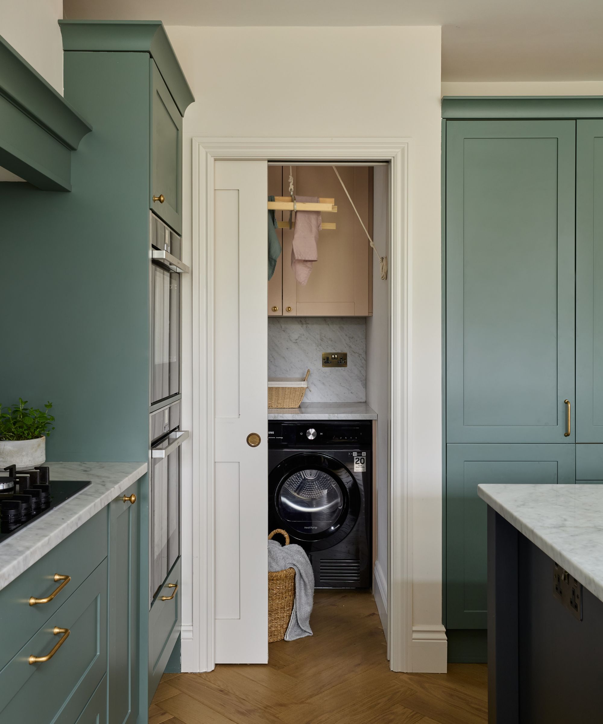 laundry room off a kitchen with a pocket door