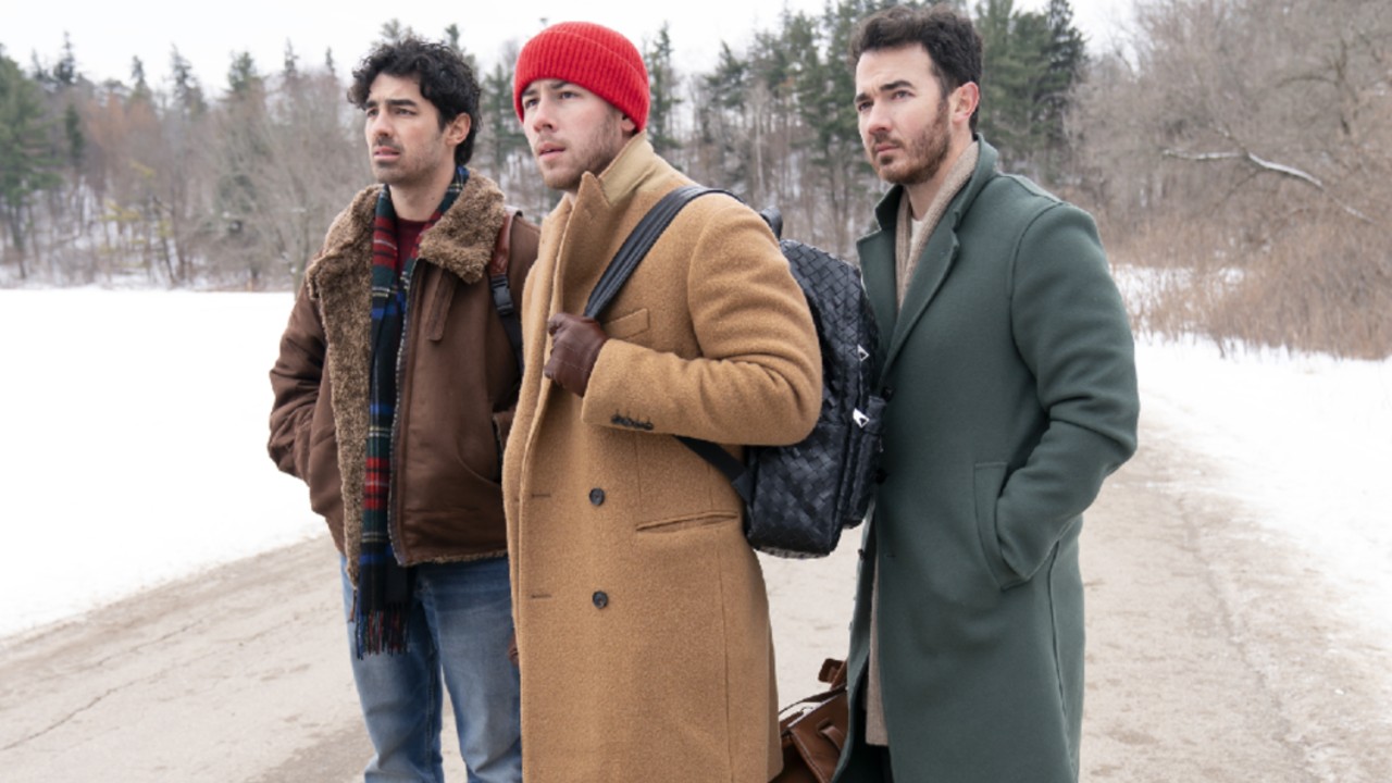 Joe, Nick, and Kevin Jonas standing on the road in A Very Jonas Christmas Movie.