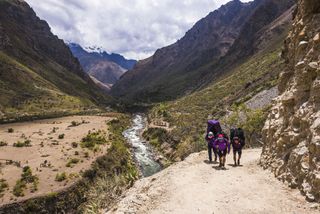 Hikers walk by the Urubamba River in Peru's Sacred Valley