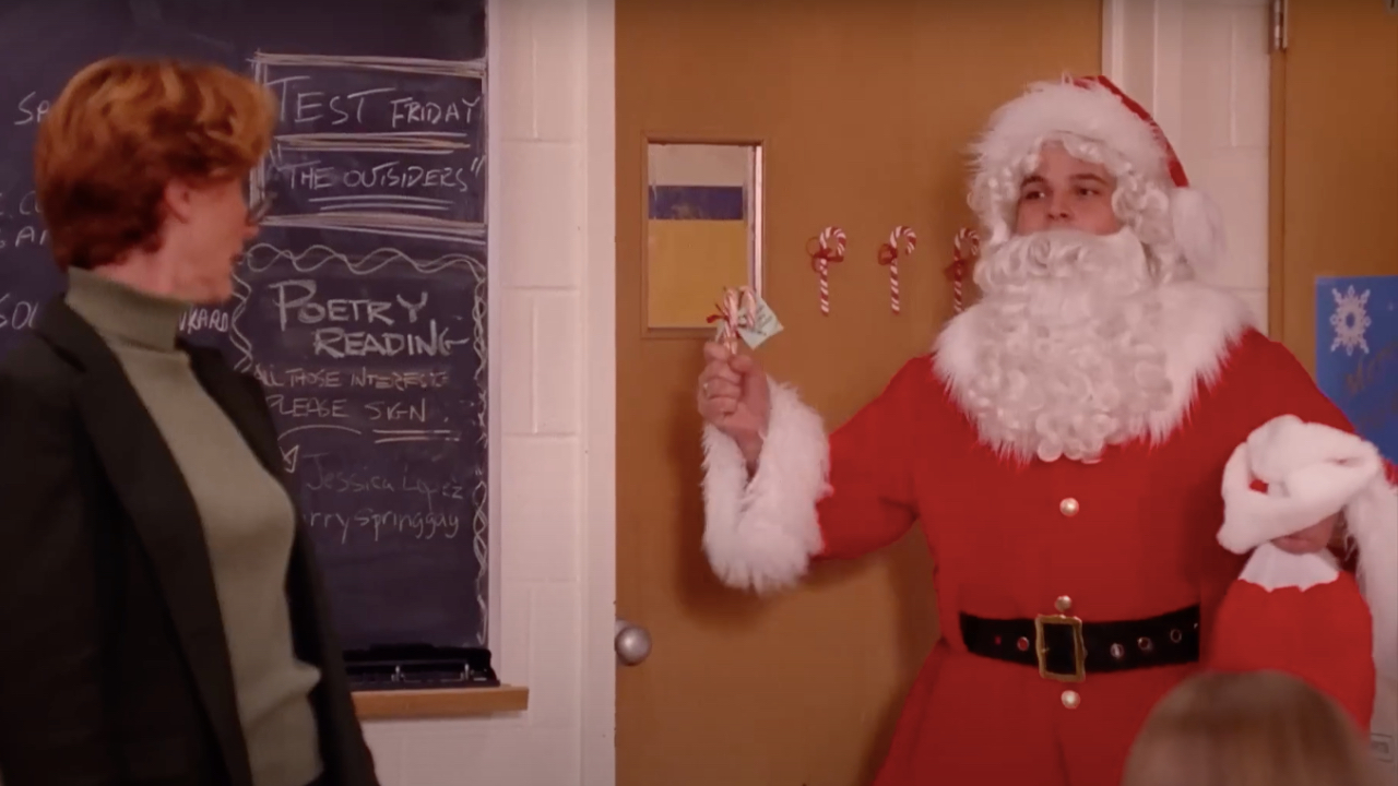 Damian in Mean Girls dressed as Santa clause handing out candy canes