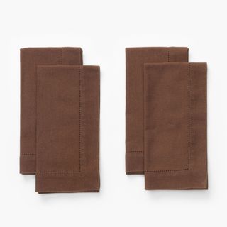 Four folded brown napkins from McGee & Co.