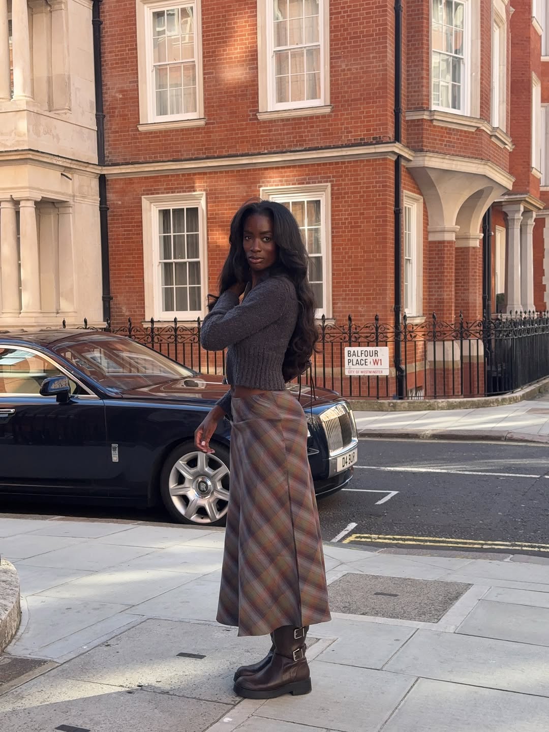 Woman wearing fall boots with skirt outfit 2025.