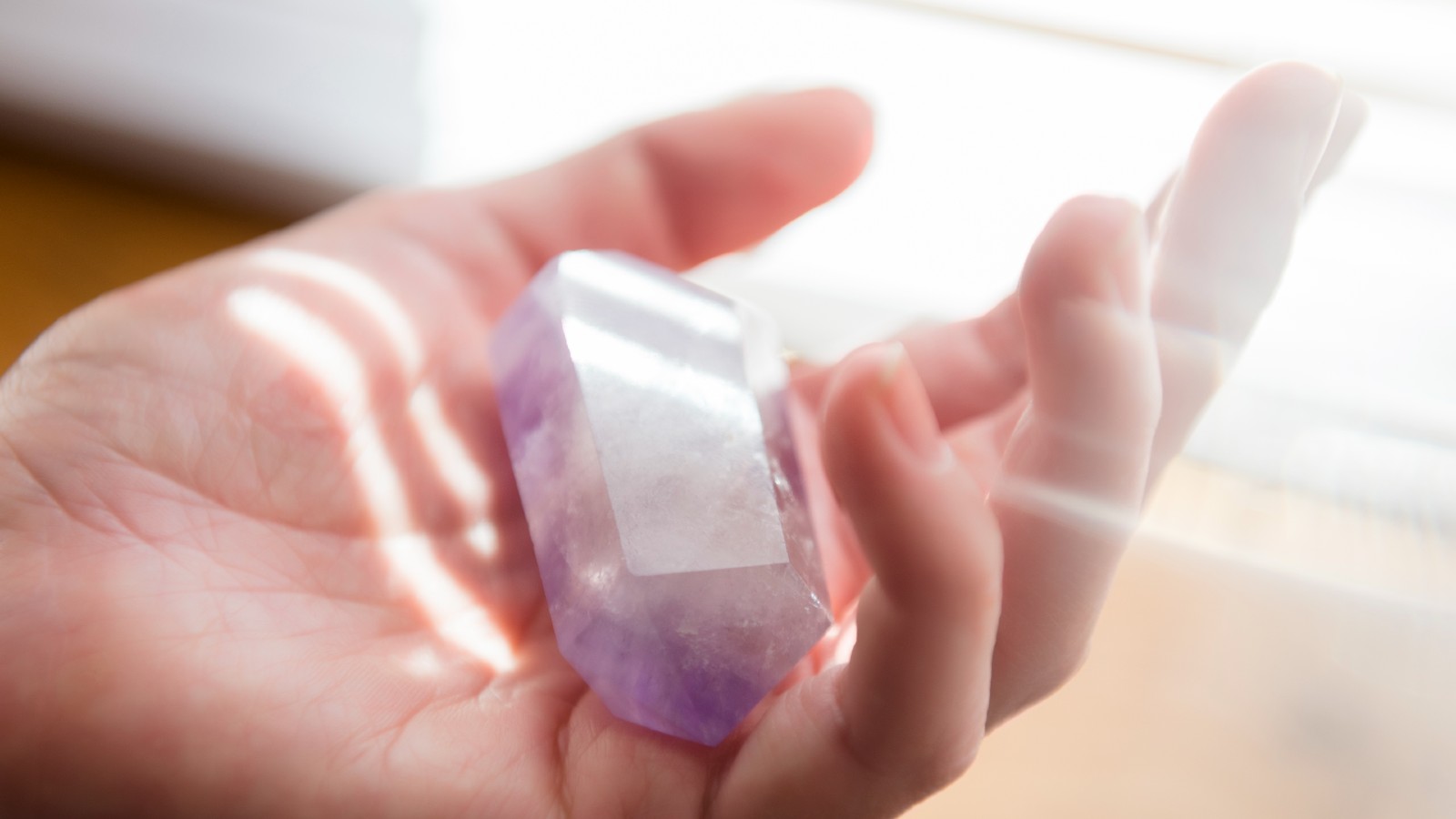 Hand of a woman holding crystal - stock photo