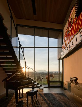 Staircase and view of horses through full-height glazing atBlack Fox Ranch, CLB Architects