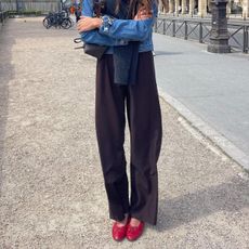 Woman in brown pants and red ballet flats