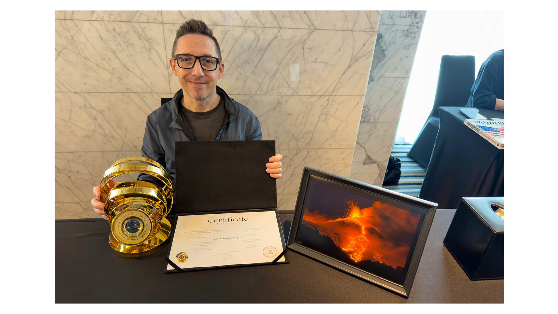 Photograph of Gianluca Gianferrari, grand prize winner of the 14th season of HIPA (the Hamdan bin Mohammed bin Rashid Al Maktoum International Photography Award), pictured with his trophy and certificate